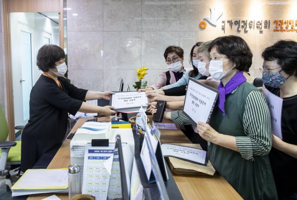 [서울=뉴시스] 전진환 기자 =  28일 오전 서울 중구 국가인권회에서 한국성폭력 상담소, 한국여성의전화 등 시민 단체들이 '고 박원순 전 서울시장에 의한 위력 성폭력 사건'과 관련해 국가인권위 측에 직권조사 발동 요청서를 전달하고 있다. 2020.07.28.    photo@newsis.com