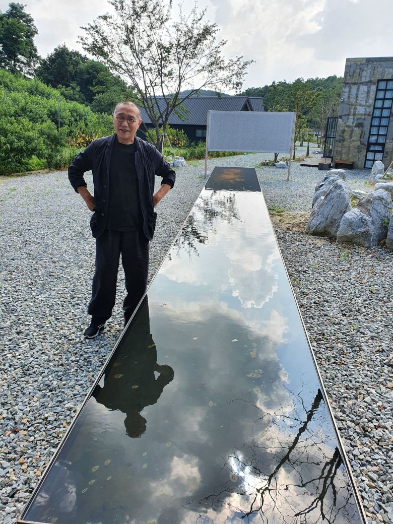 김아타 작가의 경기 여주 개인미술관인 '아르테논'. 작가 뒤로 보이는 캔버스가 자연 상태에서 2년 동안 걸어놓아 자연이 스스로 흔적을 남기게 만든 작품. /김한수 기자
