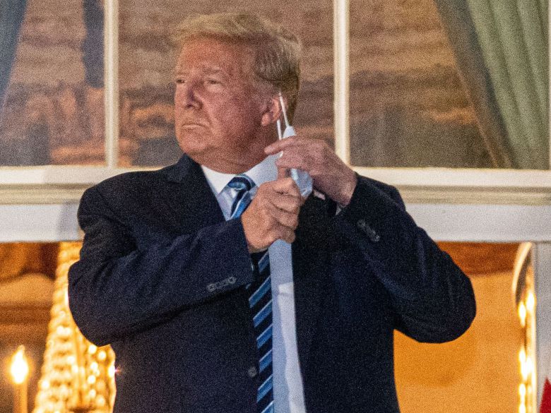 도널드 트럼프 미국 대통령이 5일(현지 시각) 퇴원 후 백악관 발코니에 서서 마스크를 벗고 있다./EPA 연합뉴스