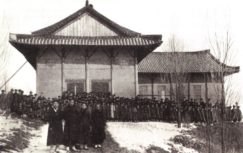 평양대부흥의 발원지인 장대현교회. 교인들 뒤로 보이는 큰 기와집이 기역자로 꺾여 있다. /조선일보DB