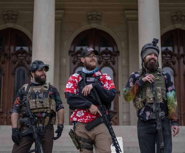 지난 17일(현지 시각) 미시간주 랜싱의 주의회 의사당 건물 앞에서 무장 민병대 소속 인사들이 총기를 들고 서 있다. /AFP 연합뉴스