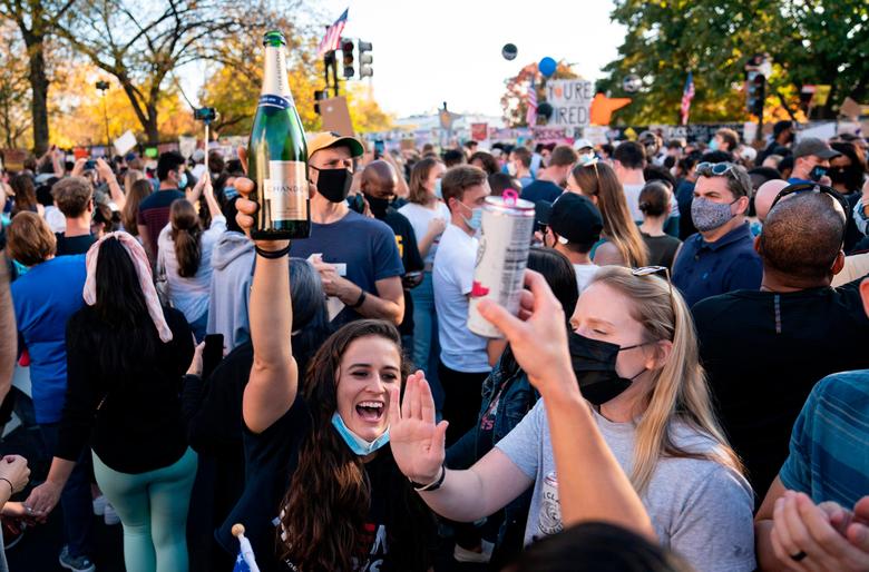 현지시각 7일 조 바이든 후보의 당선이 언론을 통해 발표되자 워싱턴 DC 시민들이 거리로 쏟아져 나와 샴페인을 터뜨리며 축하 하고있다./AFP 연합뉴스