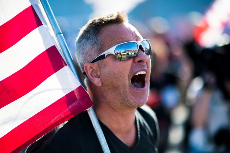 바이든 후보의 당선 소식이 알려진 7일 미국 펜실베이니아주 필라델피아에서 한 남성이 성조기를 들고 달리면서 기뻐하고 있다.  /로이터 연합뉴스