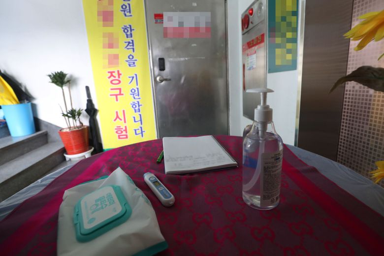 지난 24일과 25일 관련 코로나 확진자 6명이 나온 울산 아랑고고장구 지도사 자격증 시험장. 굳게 닫힌 시험장 문 앞에 체온계와 손 소독제, 방문 기록부 등이 놓여 있다. /연합뉴스