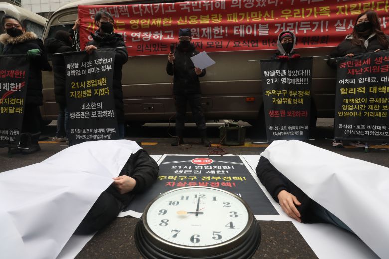 15일 오후 서울 여의도 더불어민주당 당사 앞에서 음식점, 호프 비상대책위원회 소속 자영업자들이 정부의 코로나 방역으로 실시중인 '음식점 밤 9시 이후 영업제한' 조치가 자살유발 정책이라고 주장하는 퍼포먼스를 하고 있다. /장련성 기자