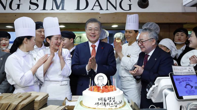 문재인 대통령이 2019년 1월 24일 전국경제투어로 대전을 방문해 성심당 빵집에서 튀김 소보로를 구매한 뒤 직원들로부터 깜짝 생일 축하 케이크를 받고 있다. /뉴시스