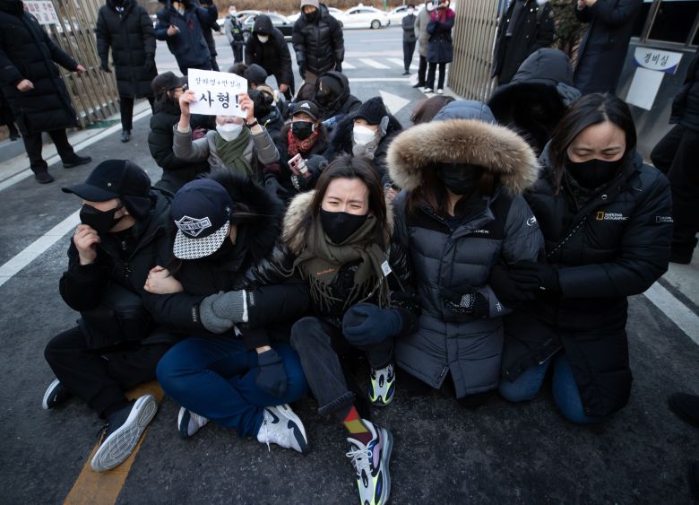 17일 서울남부지법 경내에서 시민들이 16개월 영아 정인이를 학대하다 숨지게 한 정인이 양모 장모씨가 탄 호송 차량이 빠져나가지 못하도록 도로에 앉아 길을 막고 있다. /연합뉴스