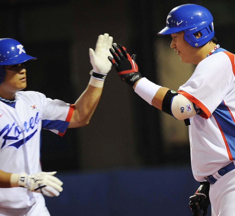 2010 광저우 아시안게임 대만전에서 추신수가 홈런 2개를 친 뒤 이대호와 하이파이브를 하는 모습.  / 조선일보DB