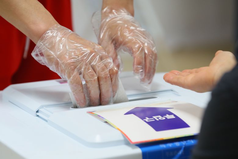 4ㆍ7재보궐선거 사전투표 이틀째인 3일 서울 광진구 자양3동 주민센터 사전투표소에서 유권자가 투표하고 있다.  2021.4.3/연합뉴스