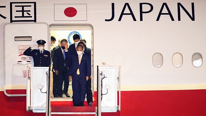 스가 요시히데 일본 총리가 15일(현지 시각) 전용기편으로 미국 메릴랜드주 앤드루스 공군기지에 도착해 문에서 나와 손을 흔들고 있다. /AP 연합뉴스