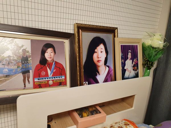 故 최숙현 선수 아버지 최영희씨가 딸을 기억하기 위해 놓아둔 사진들. 가운데 액자의 사진은 최숙현 선수의 영정 사진으로 쓰였다.