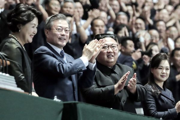 문재인(맨 앞줄 왼쪽 둘째) 대통령과 김정숙 여사가 김정은 국무위원장과 리설주 여사와 함께 2018년 9월 19일 밤 평양 능라도 ‘5월1일 경기장’에서 열린 '빛나는 조국'을 관람한 뒤 환호하는 평양 시민들에게 손을 들어 인사하고 있다.