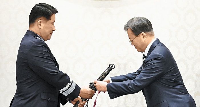 문재인(오른쪽) 대통령이 지난해 6월 당시 중장으로 진급한 박인호 공군사관학교장의 삼정검에 수치(끈으로 된 깃발)를 달고 있다. /연합뉴스