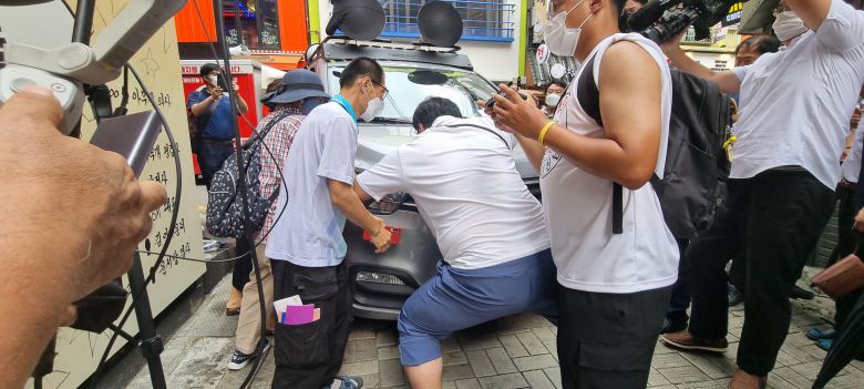 29일 오후 서울 종로구 관철동의 한 중고서점 건물 벽면에 그려진 '쥴리 벽화'를 가리기 위해 진입하는 차량을 일부 시민들이 멈춰세우고 있다. /김명진 기자