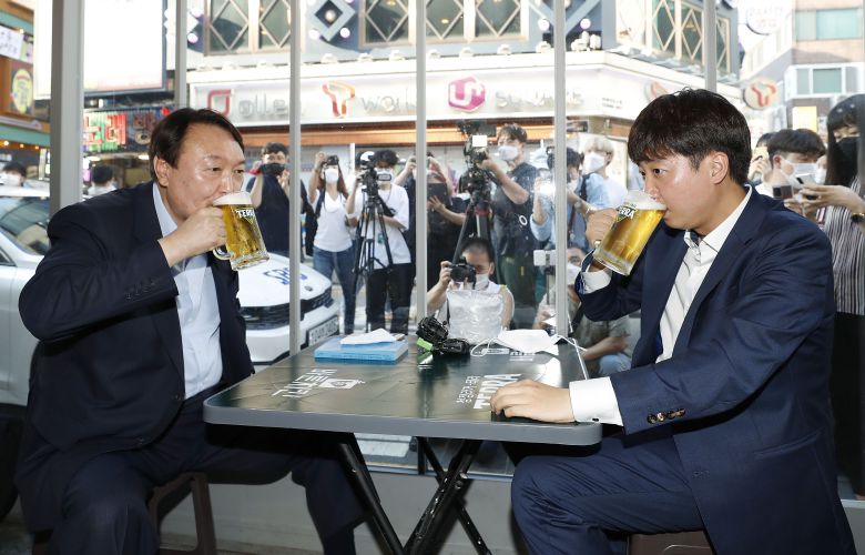 윤석열 전 검찰총장이 쩍벌 자세로 이준석 국민의힘 대표와 7월 25일 서울 광진구 건대 맛의거리에서 맥주를 마시고 있다./국회사진기자단