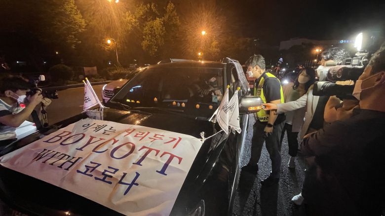 지난 26일 오후 정부 거리두기 방역 지침 등에 항의하며 '코로나19 대응 전국 자영업자 비상대책위원회'가 창원광장 회전 교차로에서 차량 시위를 벌이고 있는 가운데 경찰이 비대위 측 차량에 자진해산을 촉구하고 있다. /창원=김준호 기자
