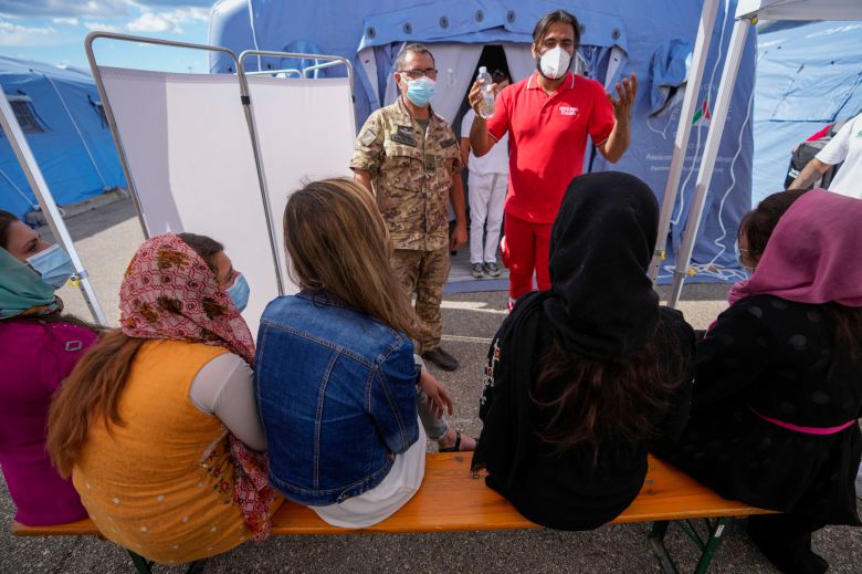 31일(현지 시각) 이탈리아 중부 아브루초에서 아프가니스탄 출신 이주민들에게 코로나 예방 백신을 접종하기 위해 현지 적십자사 관계자가 주의 사항을 전달하고 있다./AP 연합뉴스