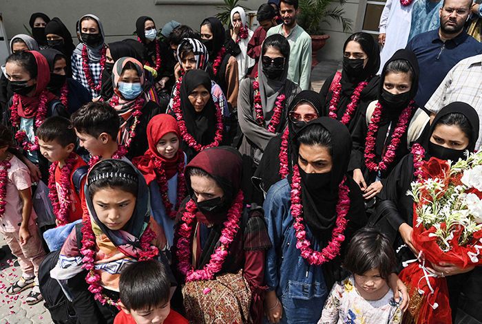 탈레반이 장악한 아프가니스탄에서 탈출한 국가대표 여자 청소년 축구팀 소속 선수와 가족, 코치 일행이 15일(현지 시각) 파키스탄 라호르에 있는 파키스탄축구협회(PFF) 본부 앞에 모여 있다. 이들은 아프간 수도 카불을 출발해 육로로 토르캄 국경지대를 거쳐 파키스탄으로 넘어왔다. /AFP 연합뉴스