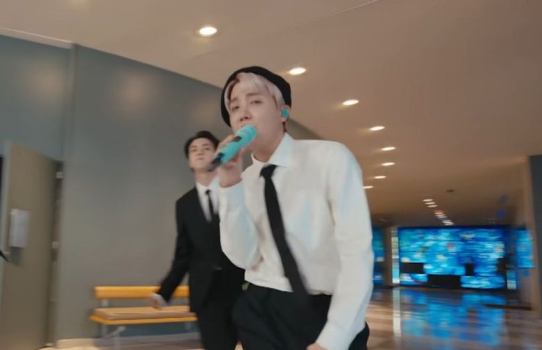 멤버들이 총회장 문을 열고 로비로 나온 장면. 뒤로 보이는 파란 스테인드글라스가 샤갈의 작품. 1961년 콩고에서 비행기 사고로 순직한 2대 사무총장 다그 함마르셸드를 추모하기 위해 만들었다./ 유엔 유튜브 캡처