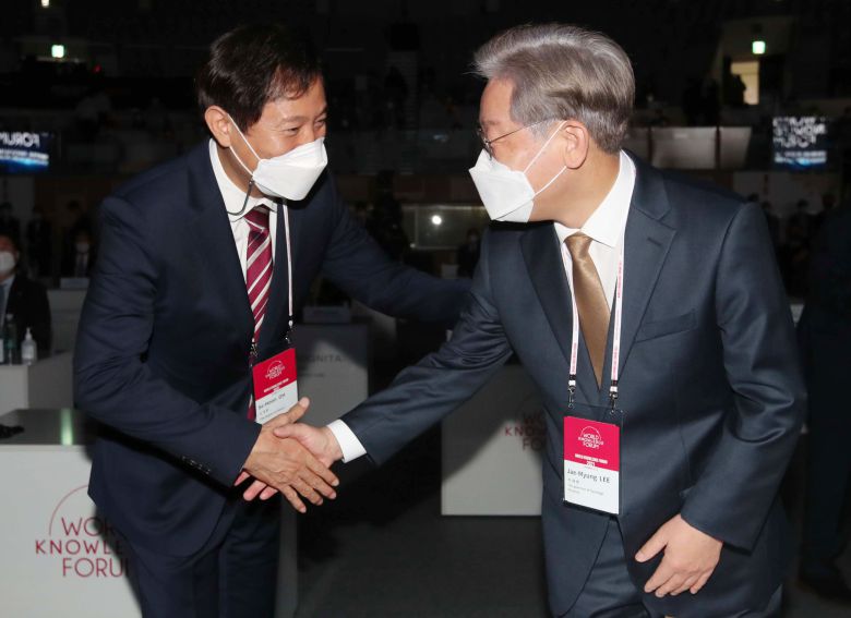 더불어민주당 대선 주자인 이재명 경기지사(오른쪽)와 오세훈 서울시장이 지난달 14일 서울 중구 장충체육관에서 열린 제22회 세계지식포럼 개막식에서 인사를 나누고 있다. /국회사진기자단