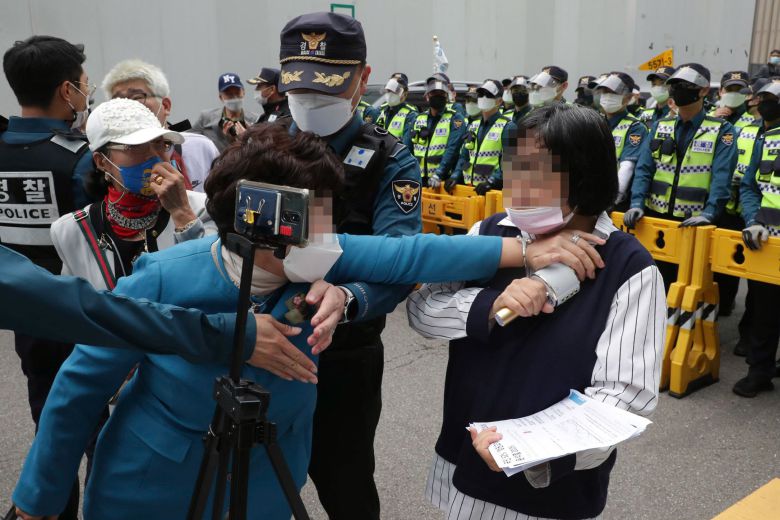 11일 오후 이낙연 후보 지지자들이 대선 후보 경선 무표효 처리 이의제기 관련해 서울 여의도 더불어민주당사 앞에서 기자회견을 하는 가운데 이낙연 후보 지지자가 유튜브 방송을 하고 있는 이재명 후보 지지자(오른쪽)를 저지하고 있다./국회사진기자단