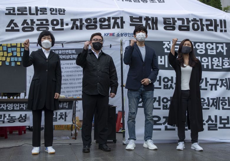 소상공인연합회 오세희 회장(왼쪽부터)과 자영업자비대위 김기홍, 이창호, 조지현 공동대표가 8일 오전 서울 세종로공원에서 소상공인, 자영업자 대책 관련 입장을 발표한 뒤 구호를 외치고 있다.  /박상훈 기자