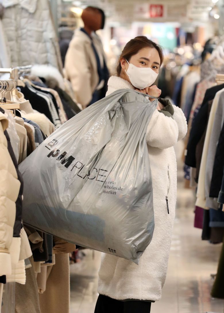 의류 쇼핑몰 '라비융'을 운영하는 김서윤(41) 씨가 서울 동대문 의류 도매시장에서 판매할 옷들을 사서 꾸러미를 짊어지고 있다. / 오종찬 기자
