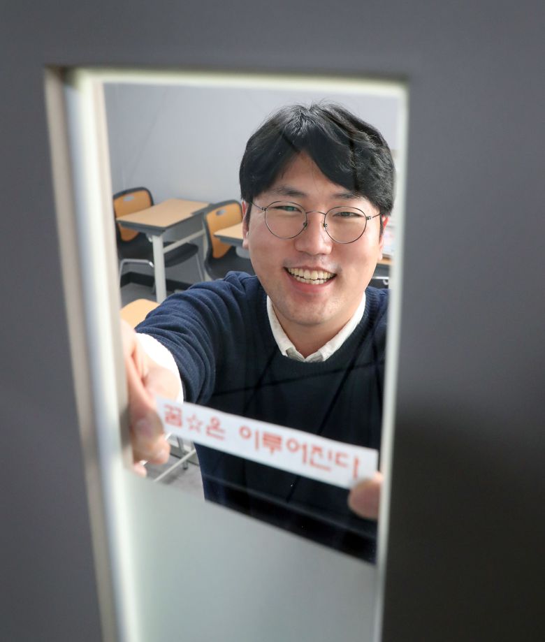 서울 대치동에서 국어 학원 '기파랑 문해원'을 운영하는 이준기(34) 씨가 학원을 정리하며 출입문에 '꿈은 이루어진다' 문구를 붙이고 있다. / 오종찬 기자