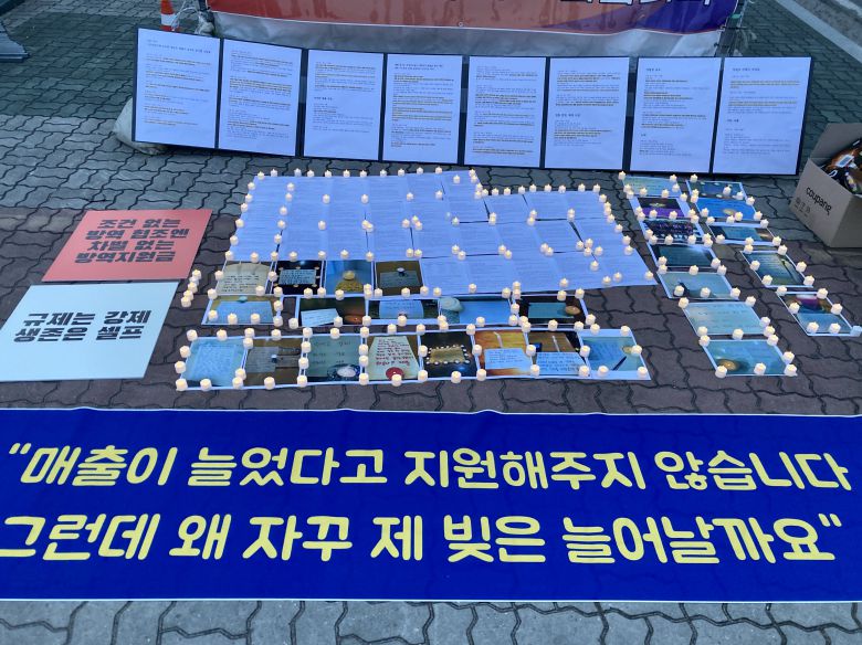 7일 오후 서울 국회의사당 앞 인도에 방역지원금 지급 제외 사례가 적힌 A4 용지들이 전자식 촛불과 함께 놓여져 있다./김정훈 인턴기자