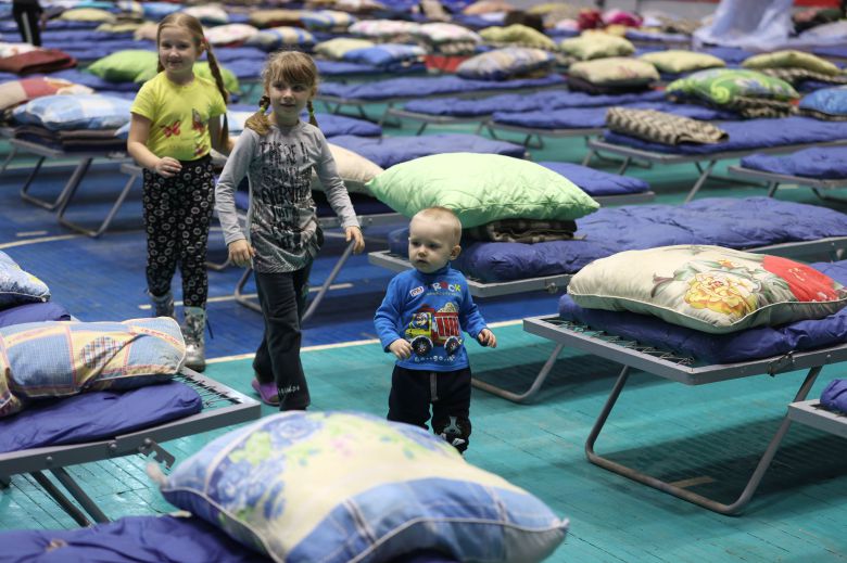 지난 20일(현지 시각) 러시아 로스토프주(州)의 항구도시 타간로크의 스포츠센터에 마련된 피란민 임시수용시설에서 어린이 세 명이 돌아다니고 있다. 이 어린이들은 우크라이나 동부 돈바스 지역에서 살다 가족들과 함께 이곳으로 대피했다/타스통신 연합뉴스
