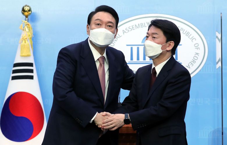 윤석열 국민의힘 대선 후보와 안철수 국민의당 대선 후보가 3일 오전 서울 여의도 국회 소통관에서 단일화 기자회견을 마친 뒤 악수하고 있다. /남강호 기자