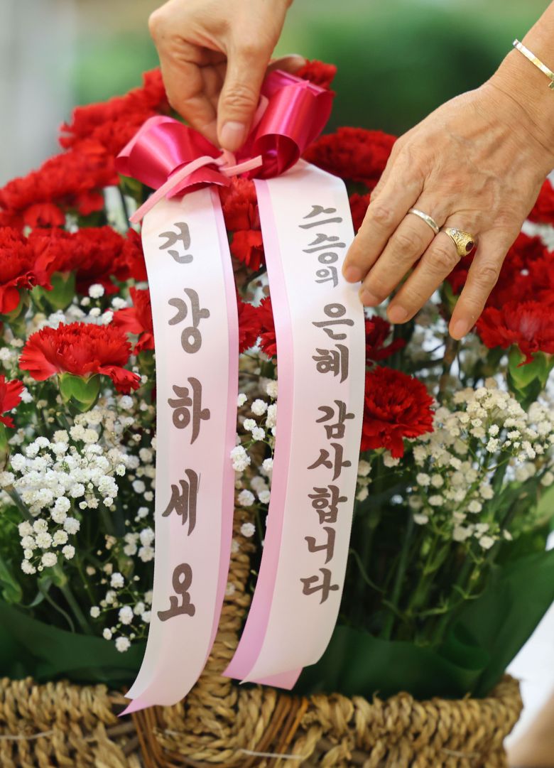 스승의날을 이틀 앞둔 13일 서울 시내의 한 꽃시장에서 상인이 카네이션 바구니에 스승의날 감사 문구가 적힌 리본을 달고 있다./연합뉴스