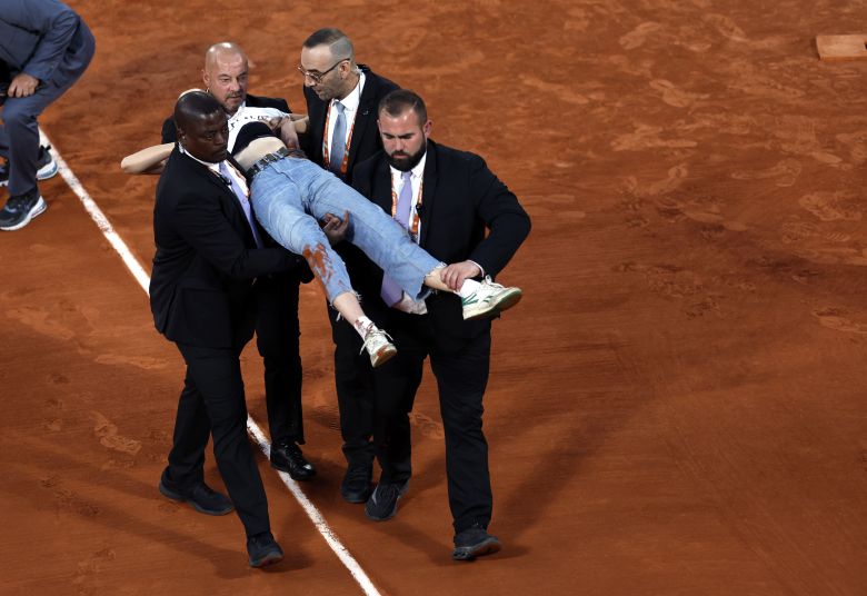 프랑스오픈 측 관계자들이 경기장에 난입한 여성을 코트 밖으로 데려가고 있다. /EPA 연합뉴스