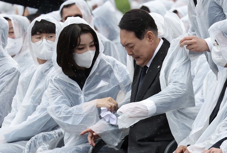 윤석열 대통령 부인 김건희 여사가 지난 6일 서울 동작구 국립서울현충원에서 열린 제67회 현충일 추념식에서 윤 대통령 젖은 옷을 수건으로 닦아주고 있다. /뉴스1