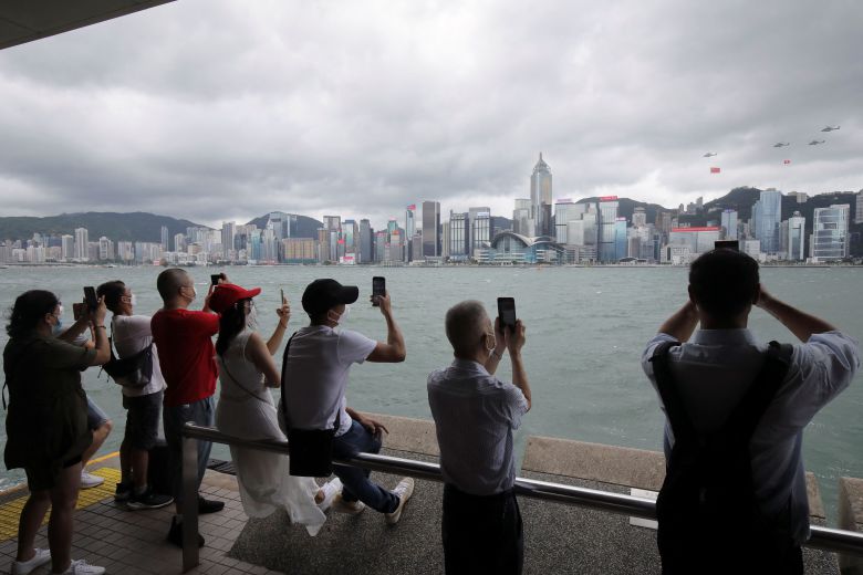 홍콩의 중국 반환 25주년인 1일 홍콩 시민들이 중국 국기와 홍콩특별행정구역기를 단 헬기의 축하 비행을 지켜보고 있다./로이터 연합뉴스