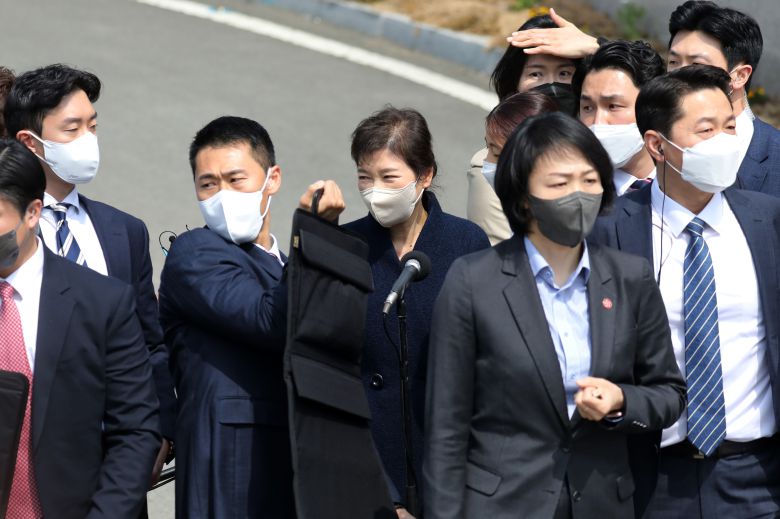 박근혜 전 대통령이 3월 24일 오후 대구시 달성군 사저에 도착해 대국민 메시지를 발표하다 한 남성이 소주병을 던지며 소란을 일으키자 경호원들의 경호를 받고 있다. /뉴스1