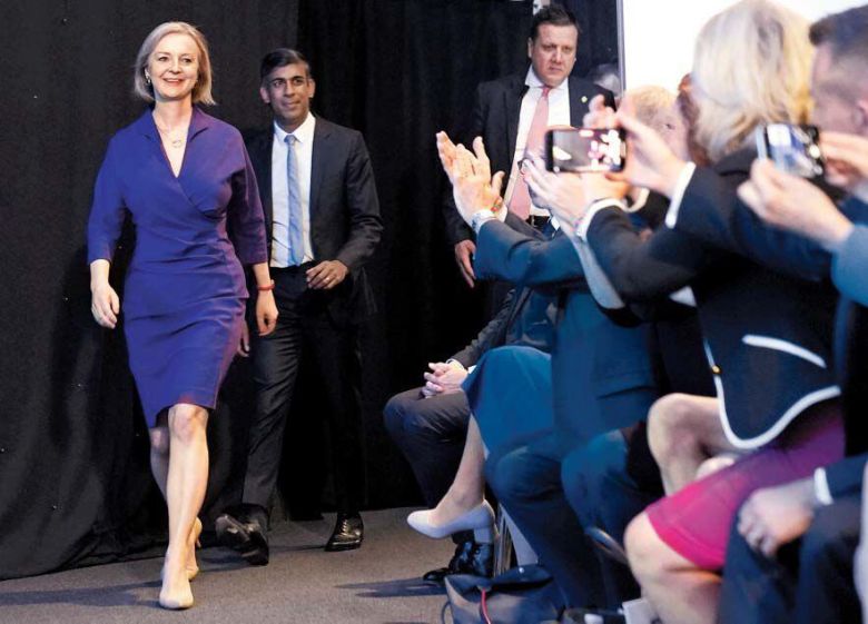 5일(현지 시각) 영국 보수당의 신임 대표 선출 투표 결과가 발표된 런던 퀸엘리자베스 2세 콘퍼런스센터 강당에 리즈 트러스(왼쪽) 외무장관과 경쟁자인 리시 수낙(바로 뒤) 전 재무부 장관이 나란히 입장하고 있다. 트러스 장관은 57.4%를 얻어 보수당의 새 대표가 됐다. 그는 마거릿 대처, 테리사 메이에 이어 영국 역사상 세 번째로 여성 총리가 됐다. /AP 연합뉴스