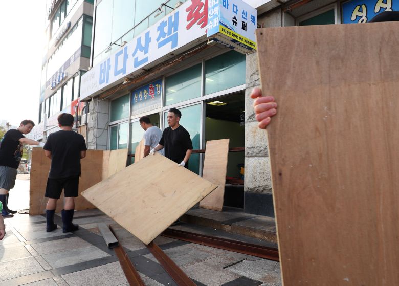 제11호 태풍 힌남노가 북상 중인 가운데 4일 오후 부산 수영구 민락수변공원 앞 상가의 상인들이 폭풍에 대비해 합판을 이용한 차수벽을 설치하고 있다.수변공원 인근에서 장사를 하고 있는 한 상인은 '20년이 다 되어 가지만 태풍 매미를 생각하면 아직도 끔찍하다'고 말했다/ 2022.09.04 김동환 기자
