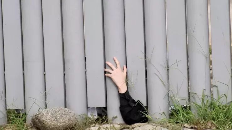 멕시코 이민청에 구금되어 있는 한 신도가 시설 밖으로 손을 내밀어 항의하고 있다. /로이터 연합뉴스