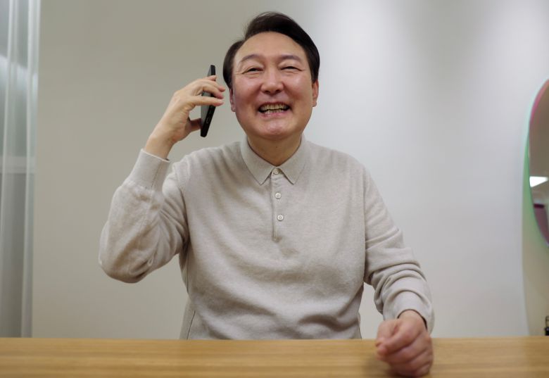 윤석열 대통령이 3일 카타르월드컵 16강 쾌거를 거둔 벤투 감독, 손흥민 선수와 전화 통화를 하며 환하게 웃고 있다. /대통령실