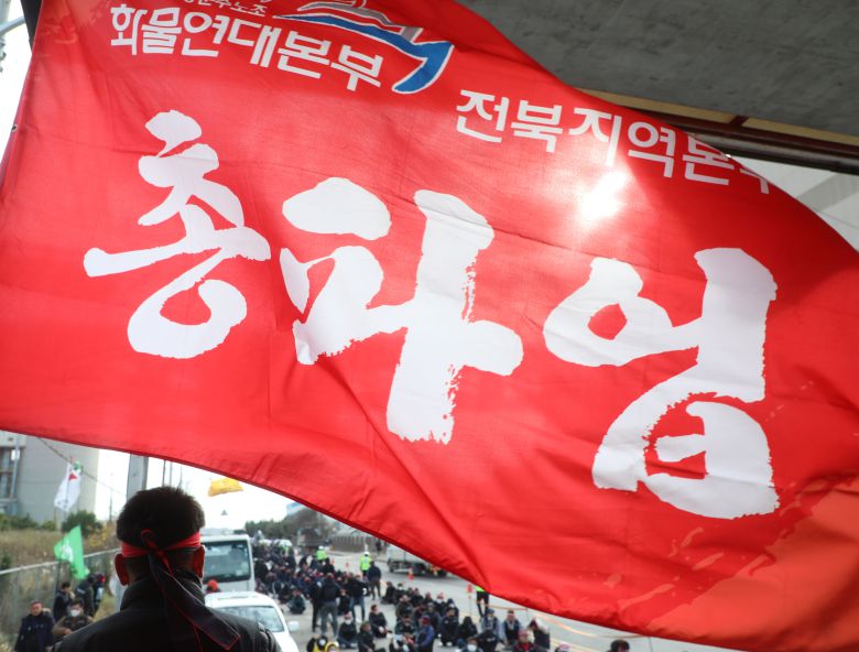 민주노총 공공운수노조 화물연대 전북지역본부 관계자들이 지난달 29일 전북 군산시 군산항 3부두 앞에서 총파업 투쟁승리 결의대회를 하고 있다./뉴스1