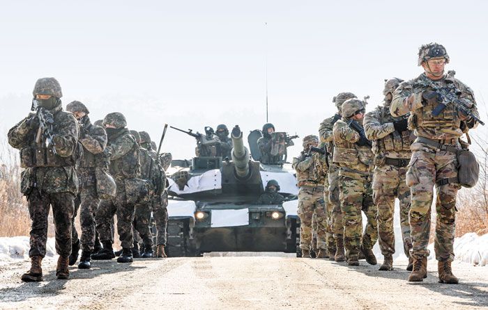 지난 11일 경기 포천 승진훈련장에서 진행된 한미 연합·제병협동 혹한기 훈련에 참석한 육군수도기계화보병사단 번개여단 전승대대 장병과, 미 스트라이커여단 미군 장병이 한국 K1A2 전차와 함께 이동하고 있다. 한미가 가상의 북한 대량살상무기(WMD) 시설을 점령하는 이번 연합훈련에는 장병 1200여 명이 참여하고, 궤도 장비 158대가 투입됐다. /국방일보