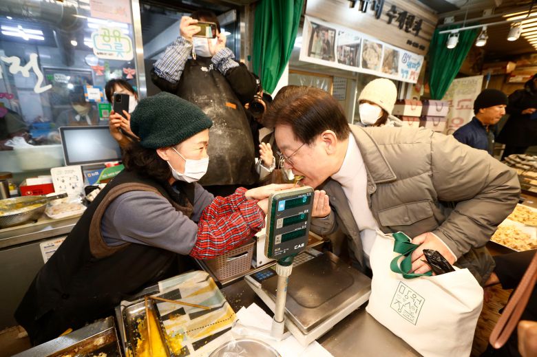 더불어민주당 이재명 대표가 설 명절을 앞둔 18일 오후 서울 마포구 망원시장을 찾아 호박전을 시식하고 있다. /2023.1.18 이덕훈 기자