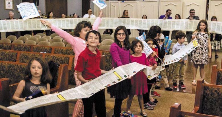 토라는 해외 거주 유대인들에게도 신앙의 구심점 역할을 해왔다. 미국 뉴욕에 있는 한 유대교 회당에서 열린 연례 토라 완독 기념행사에 참가한 어린이들이 경전 구절이 적힌 두루마리를 펼쳐 들고 서 있다. /템플 브나이 토라 오브 완타그