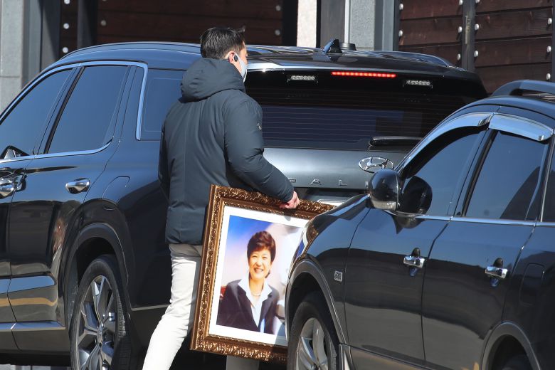 2일 오전 대구 달성군 유가읍 박근혜 전 대통령 사저 앞에서 열린 생일 축하 행사에서 황교안 전 미래통합당 대표와 지지자들이 선물한 박 전 대통령 존영(사진)과 목련이 담긴 액자를 경호처 관계자가 전달받아 들고 사저로 들어가고 있다. /뉴스1