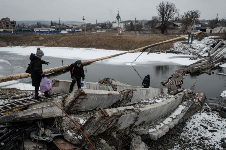 지난 1일(현지시각) 바흐무트 지역으로 향하는 운하를 건너기 위해 파괴된 다리를 걷는 시민들. /AFP 연합뉴스