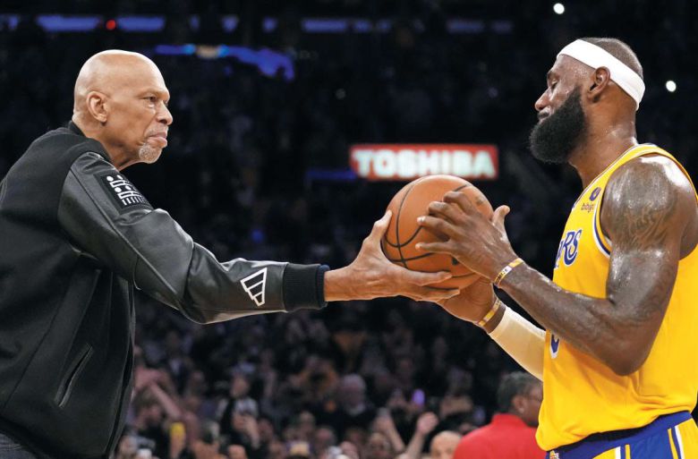 "이젠 네가 왕이다" 전설이 킹에게 - LA레이커스의 르브론 제임스(오른쪽)가 8일 오클라호마시티 선더전에서 NBA 통산 득점 기록 1위에 올랐다. 종전 NBA 통산 득점 1위였던 카림 압둘자바가 자신의 기록을 뛰어넘은 제임스에게 농구공을 전달하며 축하하고 있다. 둘 다 LA레이커스의 전설이다. 이날로 통산 3만8390점을 쌓은 제임스는 이제 전무후무한 4만점 고지를 바라본다. /AP 연합뉴스