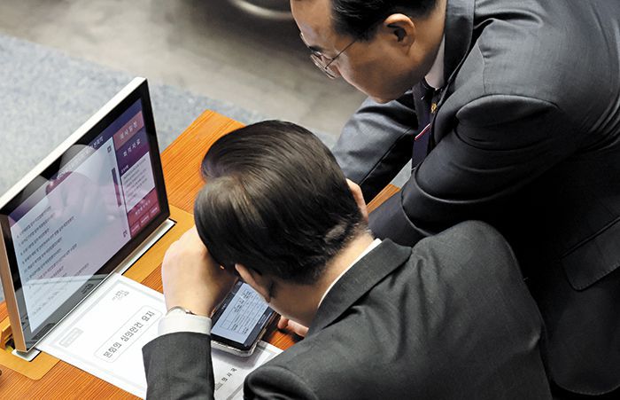 헌재 결정 확인하는 이재명·박홍근 - 더불어민주당 이재명(아래) 대표와 박홍근 원내대표가 23일 국회에서 ‘검수완박’ 입법과 관련한 헌법재판소 결정을 휴대폰으로 함께 보고 있다. 박 원내대표는 이날 기자간담회에서 “윤석열 대통령도 헌재의 판단을 무겁게 받아들여야 한다”고 했다. /연합뉴스