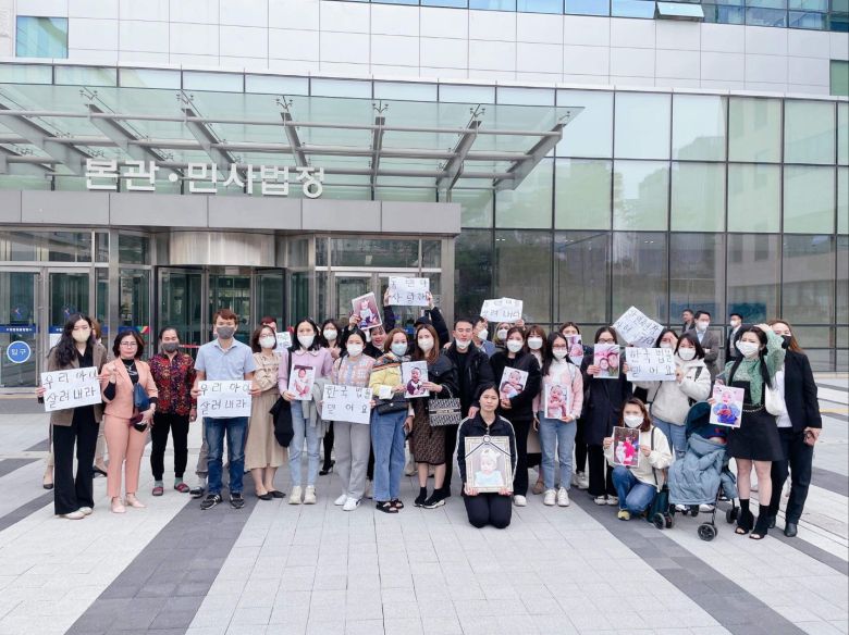 지난 24일 수원지법 앞에 40여명의 베트남인들이 모여 동민군을 숨지게한 혐의를 받는 어린이집 원장 김모씨에 대한 엄벌을 촉구하고 있다. 무릎을 꿇은 채 영정을 들고 있는 사람이 동민군의 엄마, 그의 어깨에 손을 얹은 사람이 아빠다./천안동씨 제공