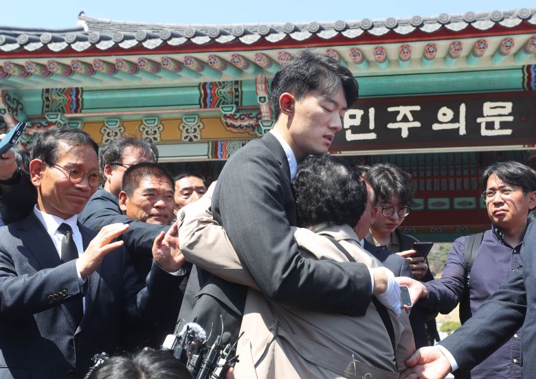 31일 오후 광주 북구 국립 5.18민주묘지 민주의문 앞에서 전두환 전 대통령의 손자 전우원씨가 고 문재학 열사 묘역을 참배한 뒤 모친 김길자 씨에게 사과하자 김길자씨가 전우원씨를 안아주고 있다. 2023. 3. 31 / 장련성 기자